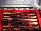 six knives in a box with a red cloth