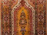 an antique persian rug with a floral design on a beige ground