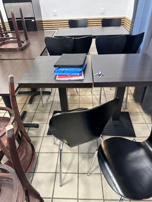 une table avec des chaises et un livre posé dessus, dans un restaurant
