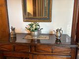 un vase de fleurs posé sur une commode en bois
