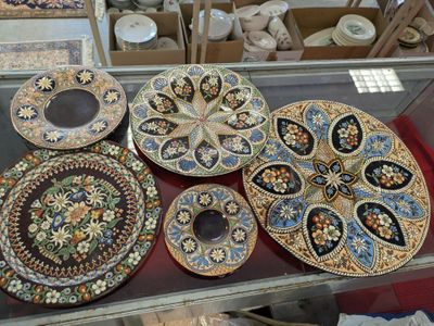 many plates and bowls on display in a glass case