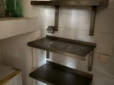 a small kitchen with a sink and shelves in it