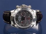 rolex watch with black dial and brown leather strap on a blue surface