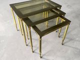 three brass nesting tables with glass tops and brass legs