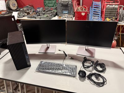 two computer monitors and a keyboard on a table