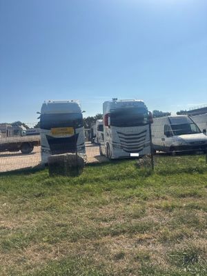 many trucks that are parked next to each other in the grass
