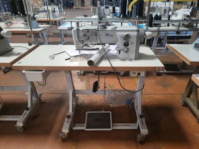 a sewing machine sitting on a table in a factory