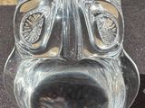 a glass sculpture of a face on a black cloth