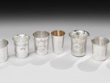 un ensemble de tasses et de cuillères en argent posées sur une surface blanche