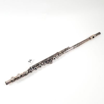 an old silver flute sitting on top of a white surface