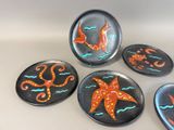 four plates with different designs on them sitting on a table