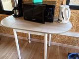 un micro-ondes et une cafetière posés sur une table dans une pièce