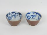 une paire de bols en porcelaine bleue et blanche posés sur un fond blanc