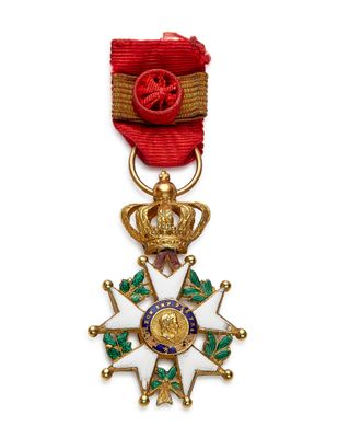 Gros plan sur une médaille sur fond blanc, accompagnée d'un ruban rouge