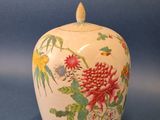 un vase blanc orné de fleurs rouges sur fond bleu