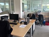 un bureau avec deux ordinateurs et une poubelle dans un coin