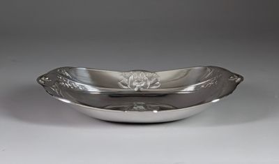 a silver plate with a flower design on it on a white surface