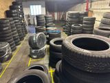 a lot of tires stacked on the floor in a warehouse