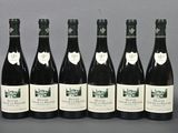 six bottles of wine are lined up in a row on a table
