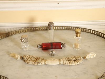 une table sur laquelle se trouvent un flacon de parfum et une brosse à dents