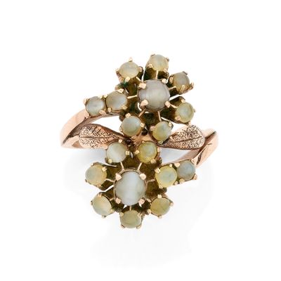 gros plan d'une bague en or avec des pierres vertes et blanches