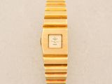 a close up of a gold wrist watch on a white surface