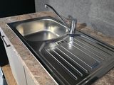 a stainless steel sink in the corner of a kitchen