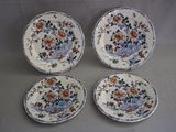 quatre assiettes à motifs floraux posées sur une table