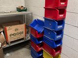 a stack of bins in the corner of a room next to a trash can