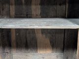 a wooden shelf that has two shelves on top of it
