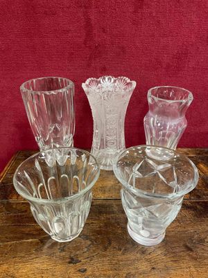 trois vases en verre posés sur une table, sur fond rouge