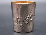 a silver cup with a flower design on it