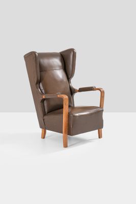 an image of a brown leather chair with a wooden frame