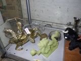a glass case with a statue of a man on a horse and other items on a table