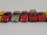 several toy cars are lined up in a row on a white surface