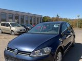 a blue volkswagen golf parked in a parking lot next to a building