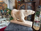 a statue of a polar bear on top of a marble block