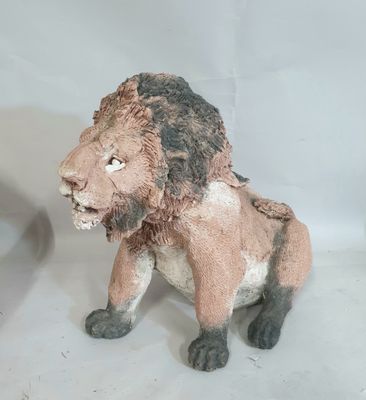 une statue représentant un lion assis sur une table