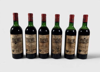 quatre bouteilles de vin sont alignées sur une surface blanche