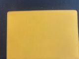 a close up of a yellow wallet on a black surface