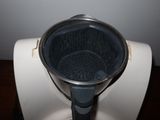 a metal strainer sitting on top of a white toilet