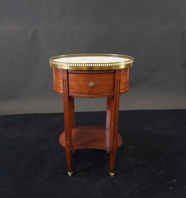 une petite table en bois sur laquelle est posé un plateau en laiton
