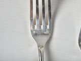 two forks that are sitting next to each other on a table