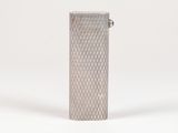 un briquet argenté posé sur une surface blanche