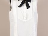 chemise blanche sans manches avec un nœud papillon noir sur un mannequin
