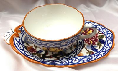 a cup and saucer on a saucer on a white cloth