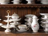 many plates and cups on a shelf in a room