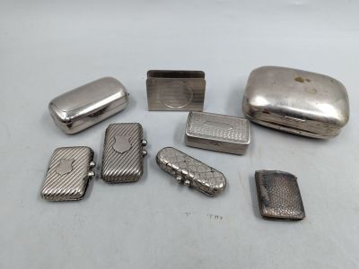 des étuis à cigarettes et des briquets argentés posés sur une surface blanche