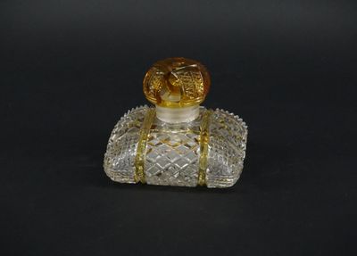 a small glass bottle with a gold lid on a black surface