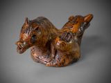 figurine représentant un cheval couché sur le dos sur une surface grise